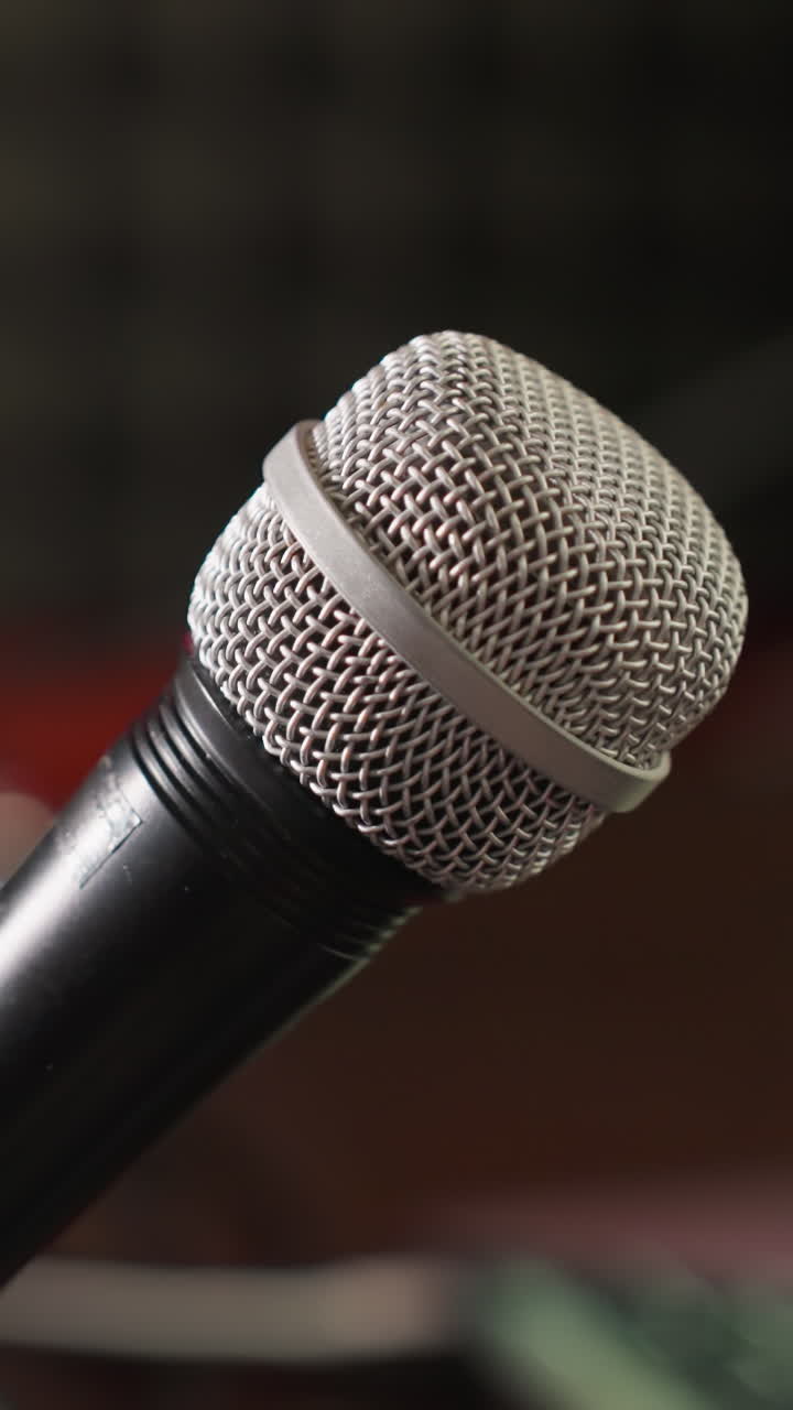 toma de primer plano de un micrófono en un soporte con un fondo borroso, destacando el micrófone como el punto focal. herramienta esencial para la grabación de audio o radiodifusión, con el fondo borroso