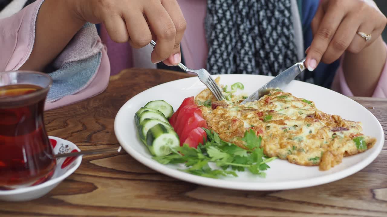 터키 차 와 함께 맛있는 오멜 아침 식사를 즐기는 여자