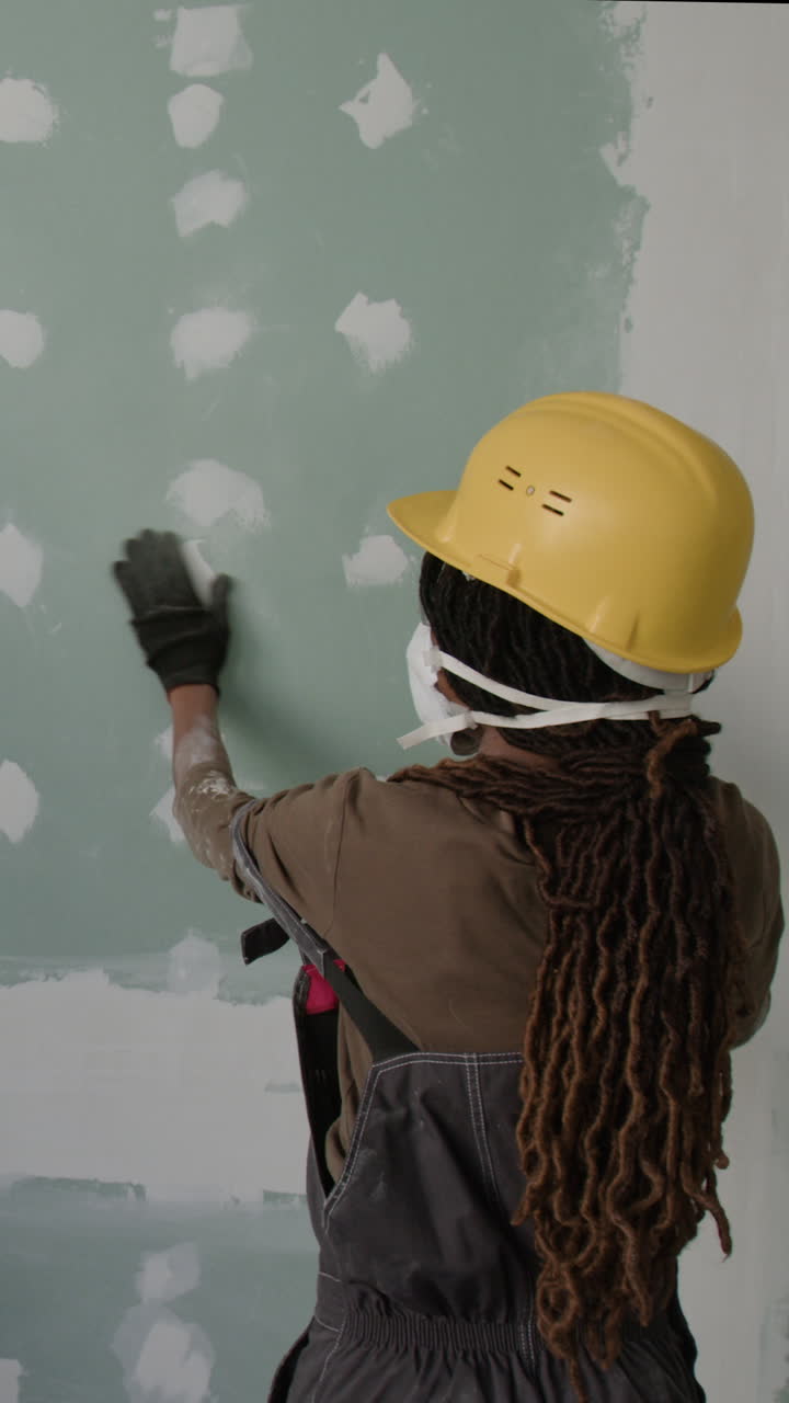 Construction worker repairing a drywall