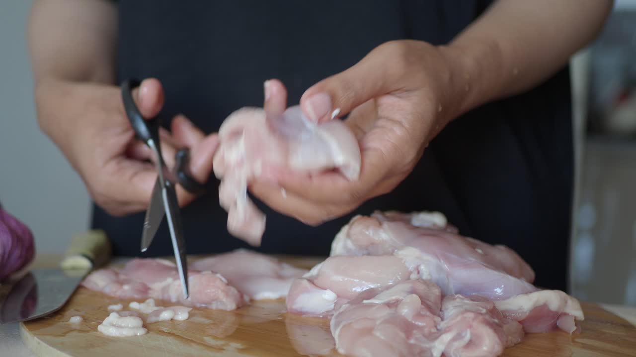 Woman Cutting Raw Chicken