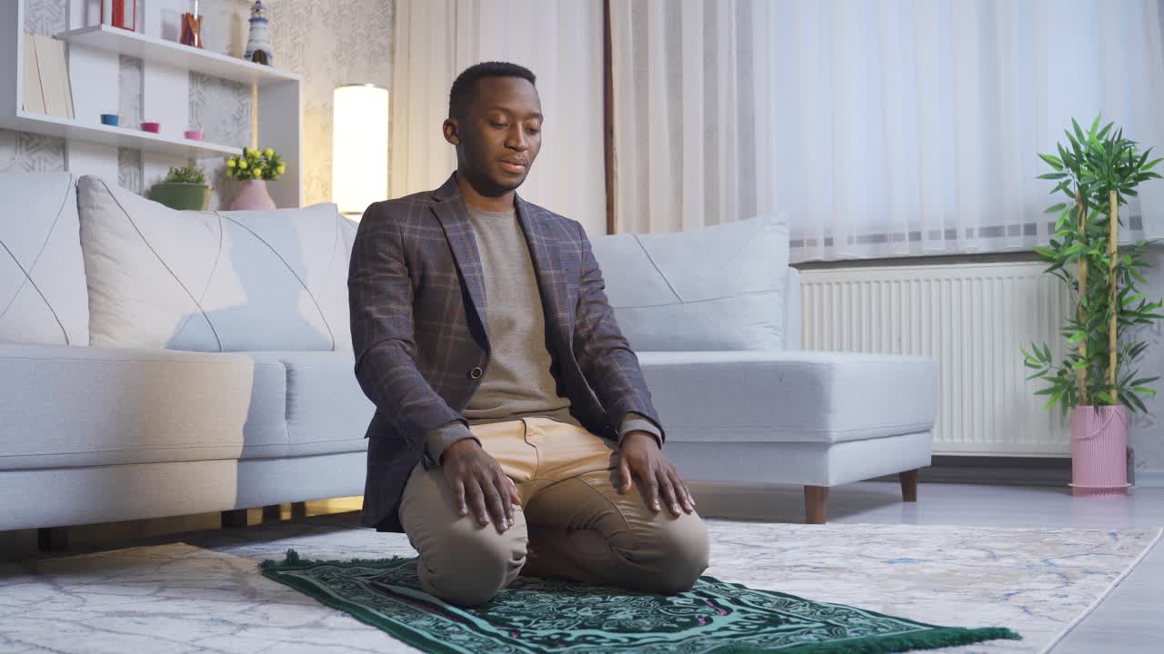 Jeune homme musulman africain priant à la maison, adorant Allah.