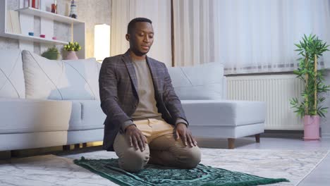 African-Muslim-young-man-praying-at-home,-worshiping-Allah.