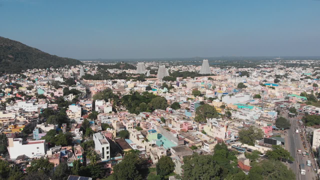 sobrevuelo aéreo ciudad brillante de tiruvannamalai con torres de templos en el fondo durante el cielo azul y el día soleado