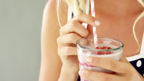 una mujer bebiendo un batido.