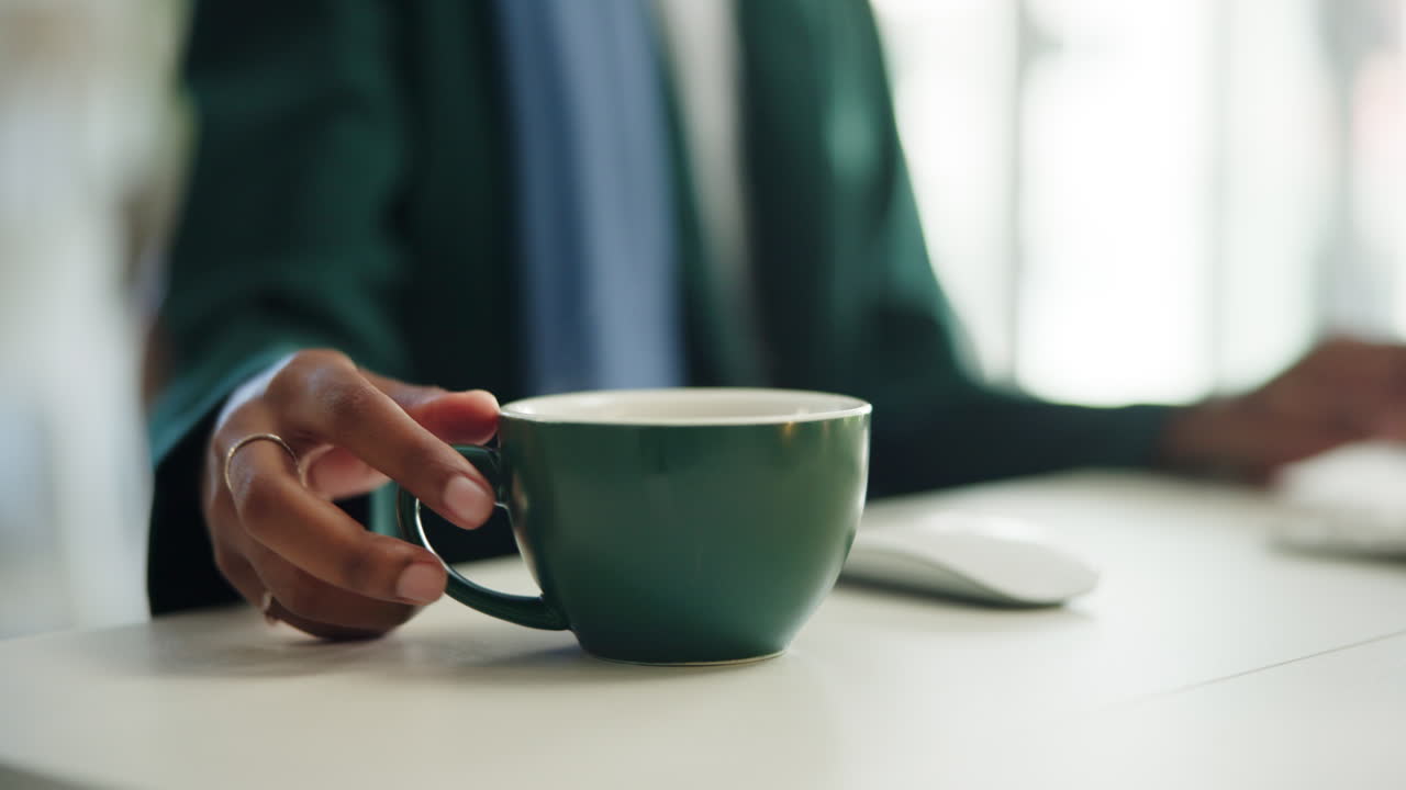 Close-Up Cangkir Kopi Beruap di Meja Saat Seseorang Bekerja