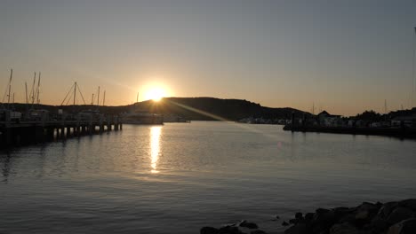 Timelapse-view-of-sun-setting-behind-mountain-range-at-Hamilton-Island-marina,-Queensland