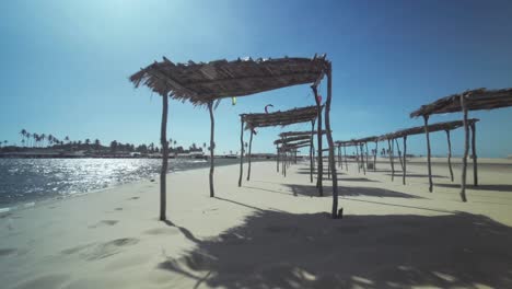 cabañas de playa en un día soleado en brasil con kiteboarders surfeando en la costa