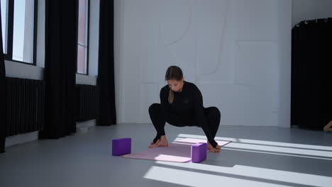 woman doing yoga stretches in a studio