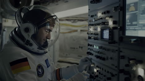 astronaut operating control panel in spacecraft