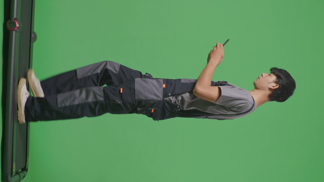 노동자 가 트레드밀 을 고 전화 를 보고 있다