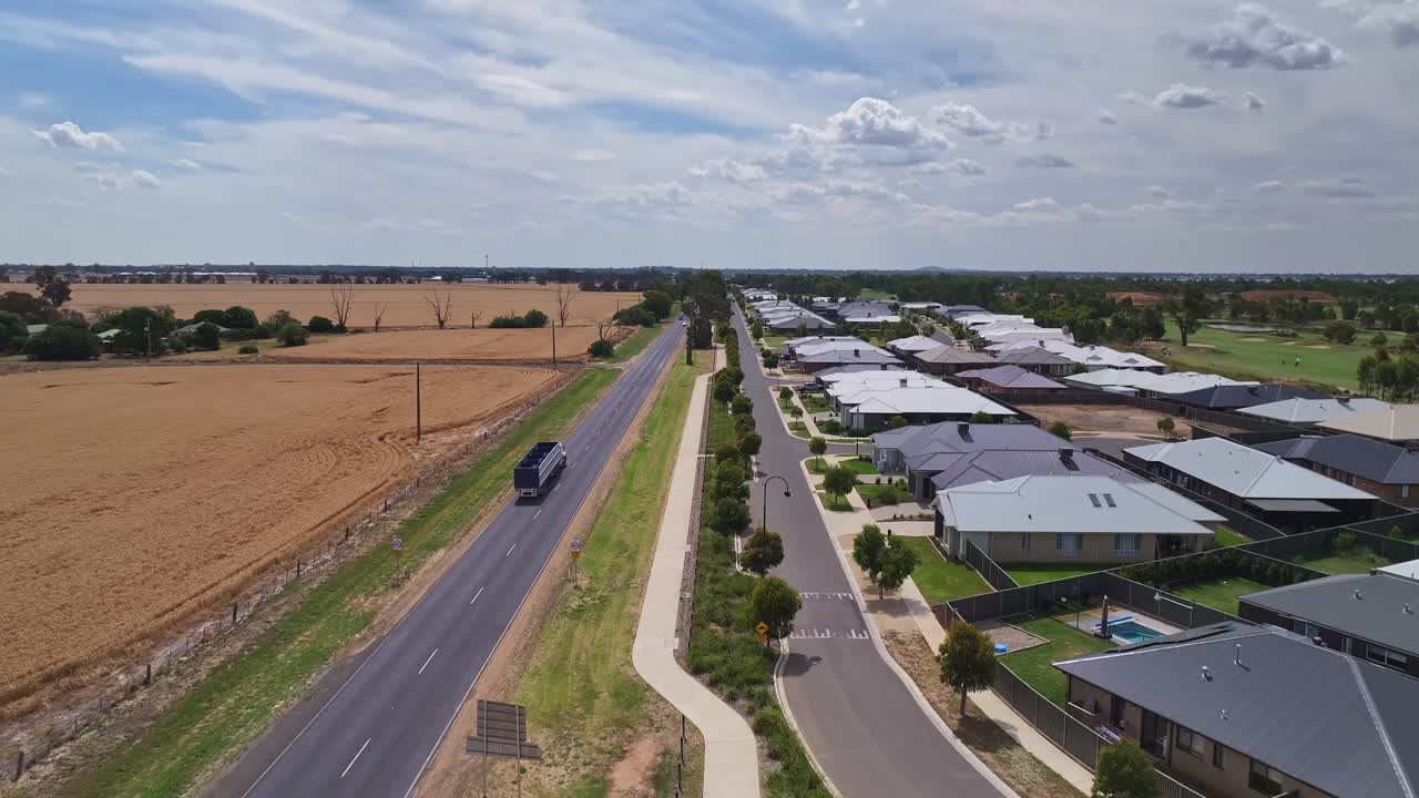 고속도로 양쪽에 새로운 집과 농장 들 이 있는 미들랜드 고속도로 에 있는 교통의 오버헤드
