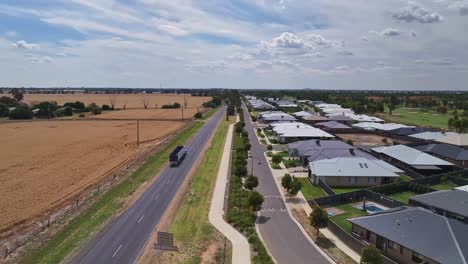 Overhead-of-traffic-on-the-Midland-Highway-with-new-houses-and-farm-fields-either-side-of-Highway