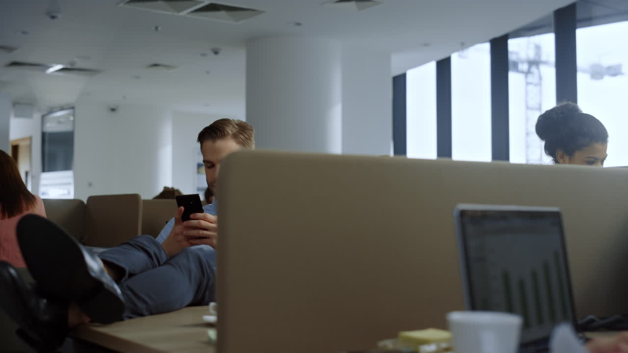 hombre de negocios usando un teléfono inteligente en una oficina moderna. empleado masculino enviando mensajes de texto