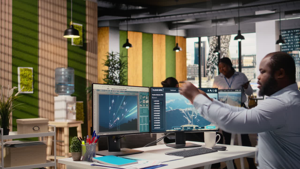 Worker Enters Office, Uses Electric Grid And Wind Farm Layout Optimization Tools