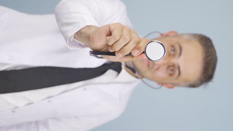 vertical video of doctor listening to camera with stethoscope.