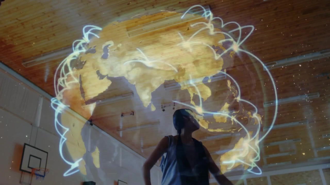 Students raising and guiding networked holographic globe with faint glow emerging in education gym
