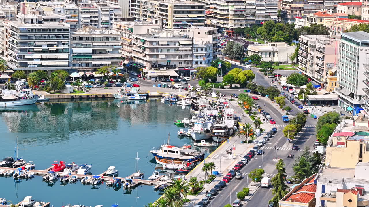KAVALA, GREECE - SEPTEMBER 23, 2020: Aerial view of the city. Rows of residential buildings, Aegean sea port with moored yachts, roads with people and cars
