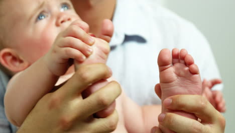 el primer plano de un bebé en los brazos de su padre