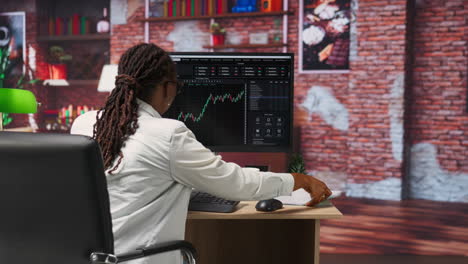 forex trader browsing though stock exchange portfolio pages at computer desk