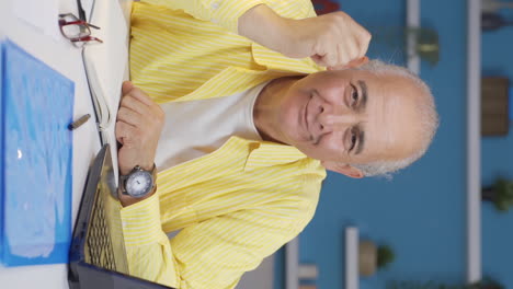 Vertical-video-of-Home-office-worker-old-man-expressing-his-mind-and-success-to-the-camera.