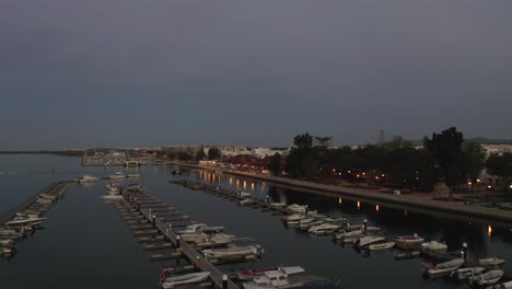 Wunderschöner-Meerblick-Auf-Die-Stadt-Olhao-Bei-Nacht-Mit-Wunderschönen-Lichtern,-Die-Sich-Im-Wasser-Spiegeln