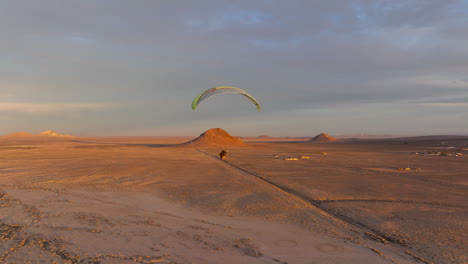 power paragliding over the mojave desert landscape during a stunning sunset - aerial follow