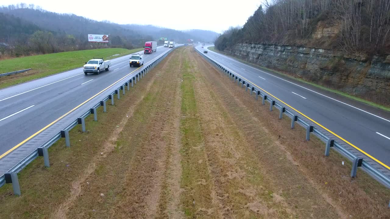 4k autopista aérea subiendo jib disparó camiones vehículos de transporte conduciendo en la carretera de tennessee