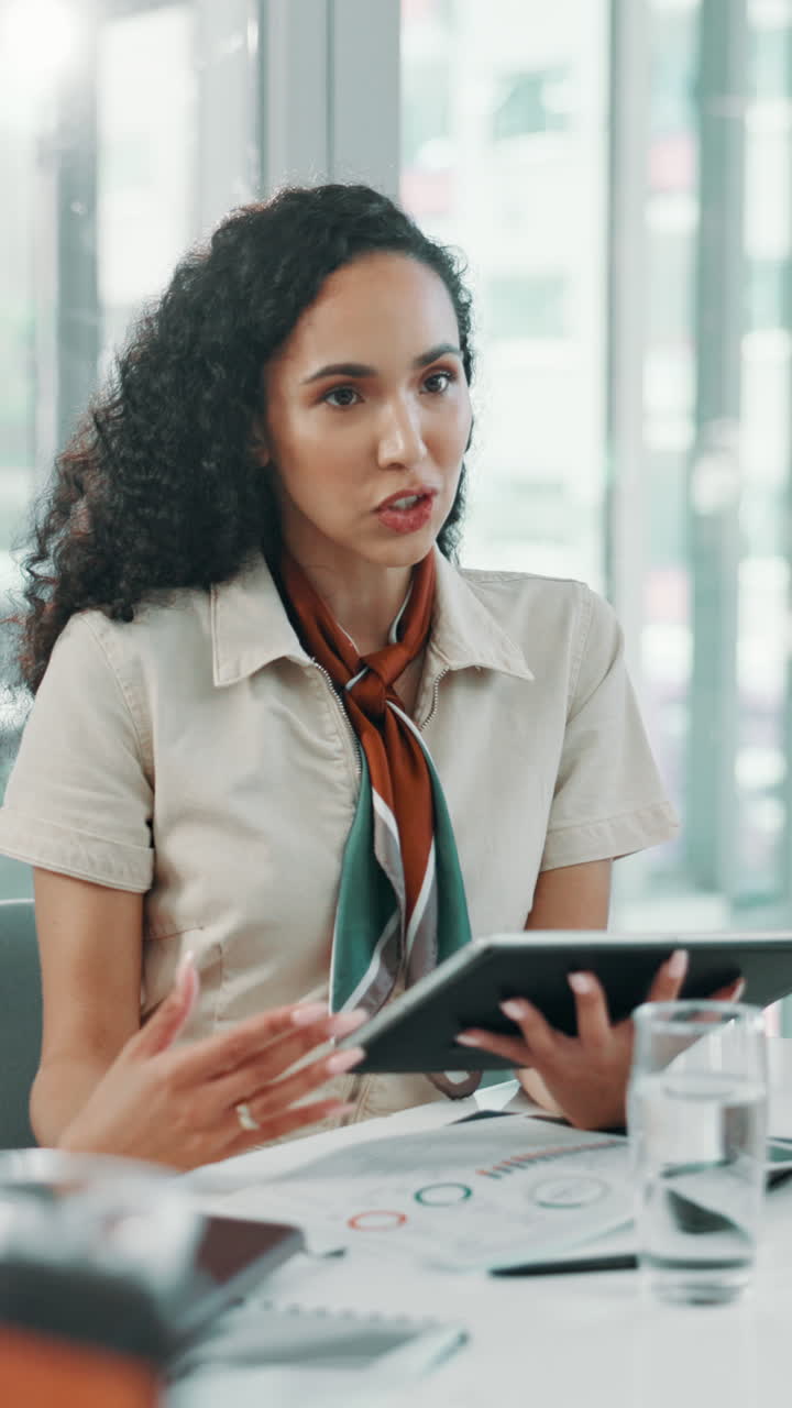 Donna Professionista Che Parla e Gesticola con il Tablet in una Riunione d'Ufficio