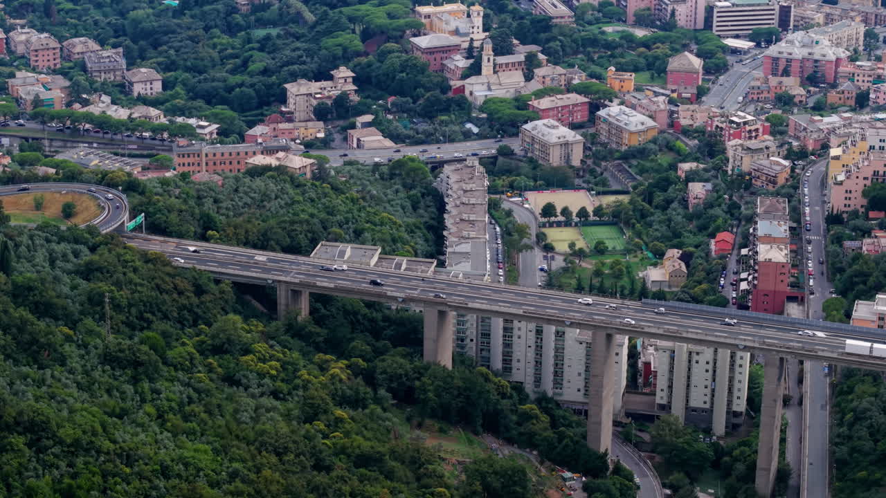 Vista aerea del ponte autostradale di Genova su un paesaggio rigoglioso ed edifici della città