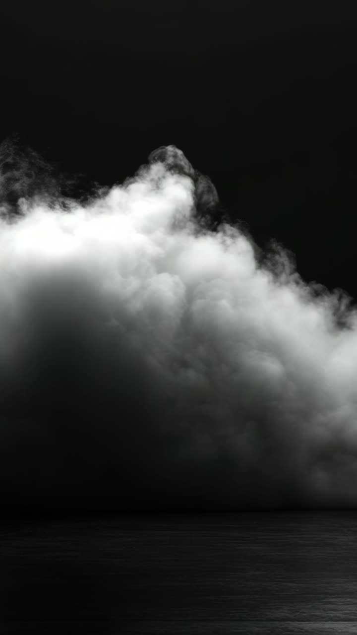 Clouds over calm water. Thick, dark clouds roll over a calm, reflective surface, creating a moody atmosphere during dusk.