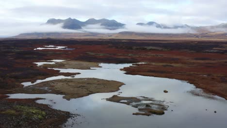 drone view over dramatic icelandic landscape, low cloud around mountains