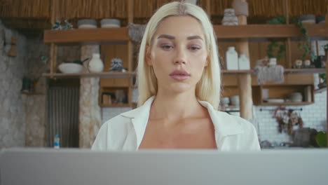 woman working on a laptop in a kitchen