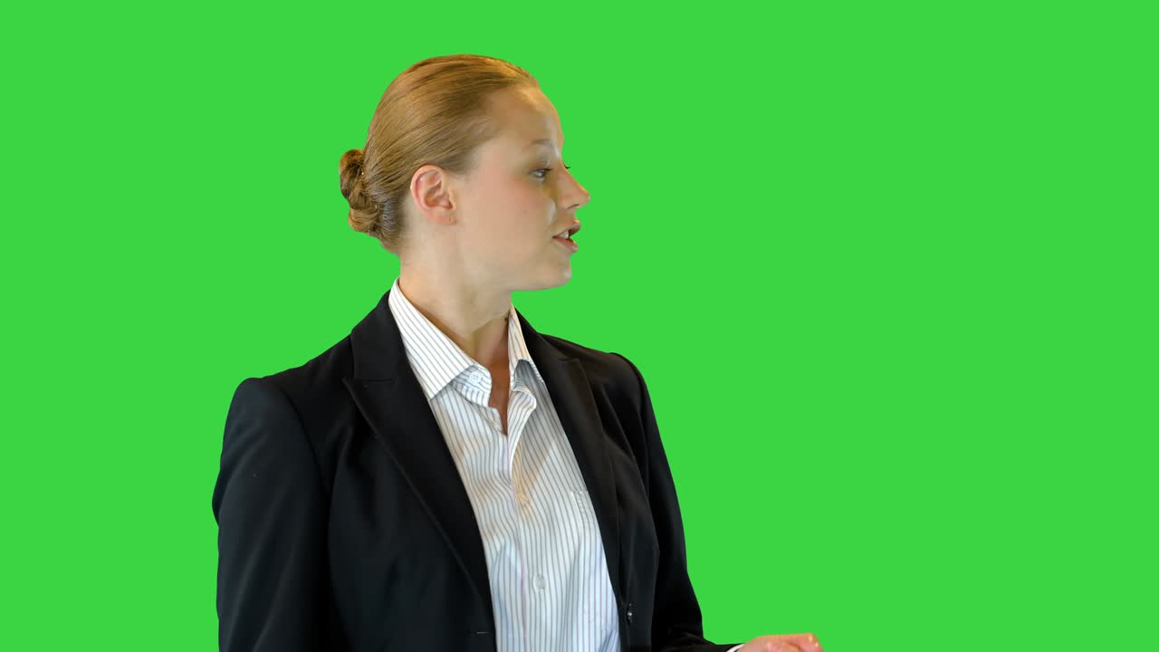 Beautiful blonde business woman presenting something pointing with her hand to the side on a Green Screen, Chroma Key