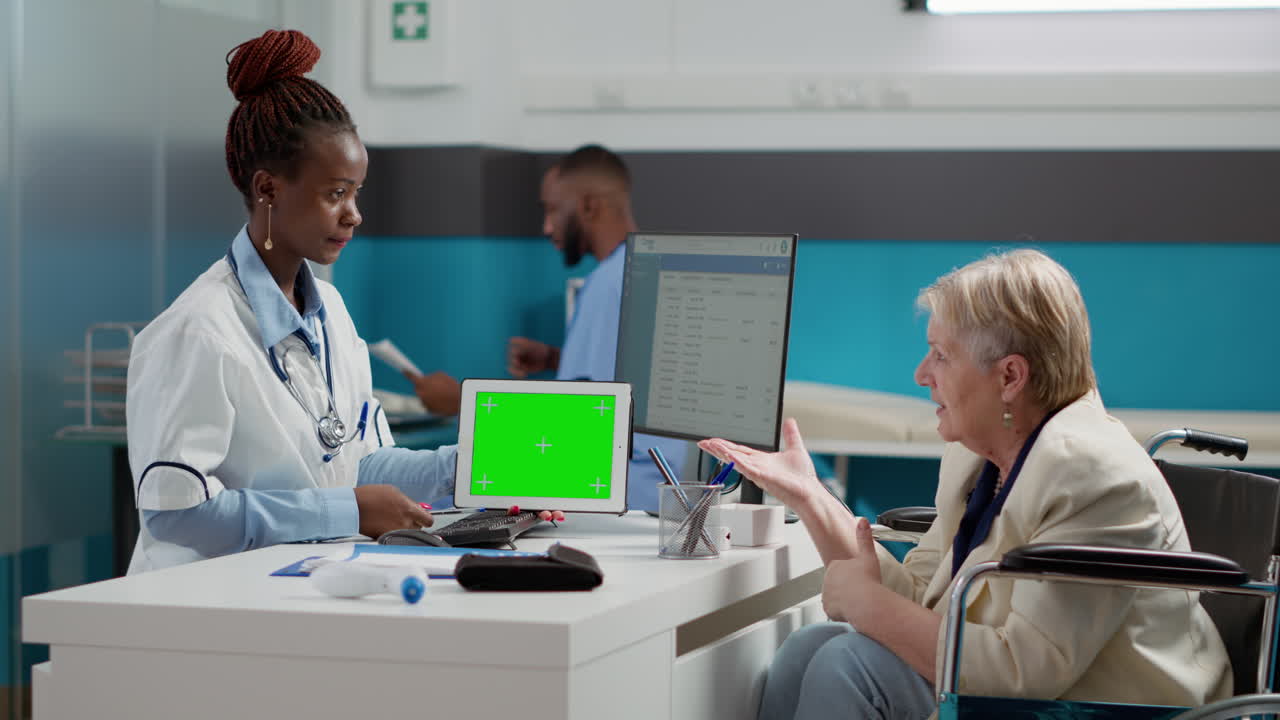 Doctor using tablet with green screen to consult with patient