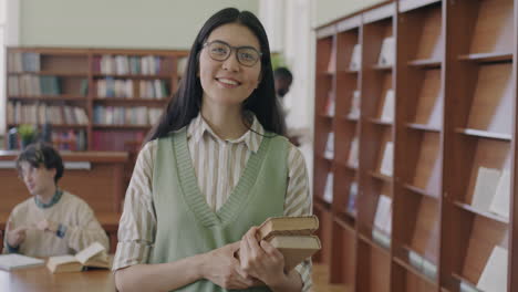 mujer sosteniendo libros en una biblioteca