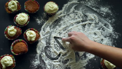 inscription cakes on white flour spills at kitchen table. baking cupcake concept