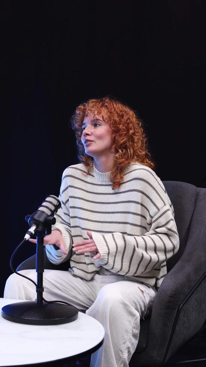 Giovane donna con capelli ricci rossi che registra un podcast