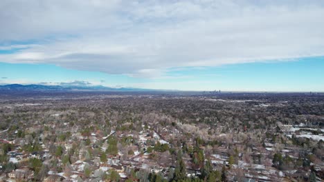 Drone-aerial-view-of-Denver,-Colorado-and-the-rocky-mountain-range-in-winter