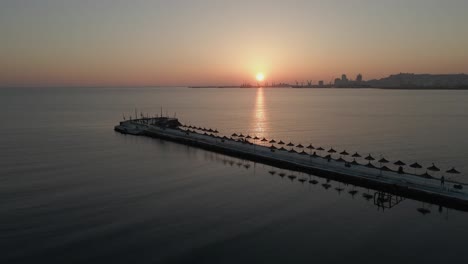 Adriatic-sunset-aerial-of-jetty-and-distant-port-in-Durres,-Albania