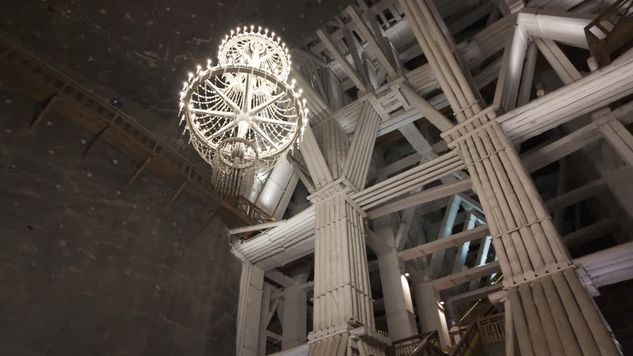 Chandelier glows amid wooden beams in Poland's Wieliczka Salt Mines interior
