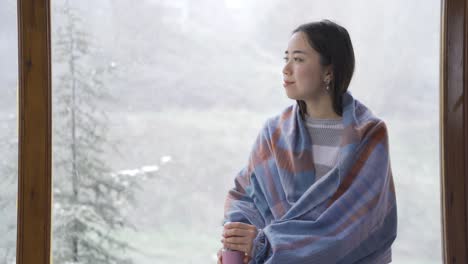 happy asian young woman enjoys winter by the window.