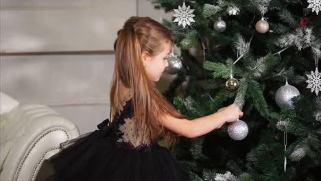little girl decorating christmas tree