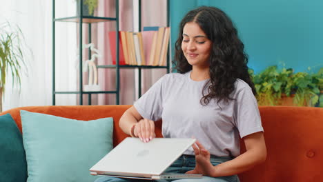 Junge-Freiberufliche-Frau,-Die-Nach-Beendigung-Der-Arbeit-Im-Wohnzimmer-Zu-Hause-Auf-Der-Couch-In-Der-Nähe-Eines-Laptop-PCs-Sitzt