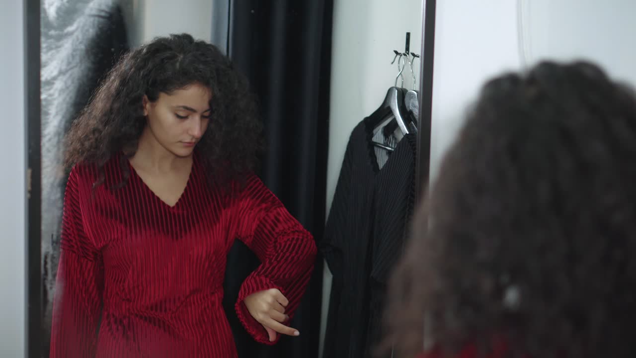 Woman Trying On a Red Dress in a Fitting Room
