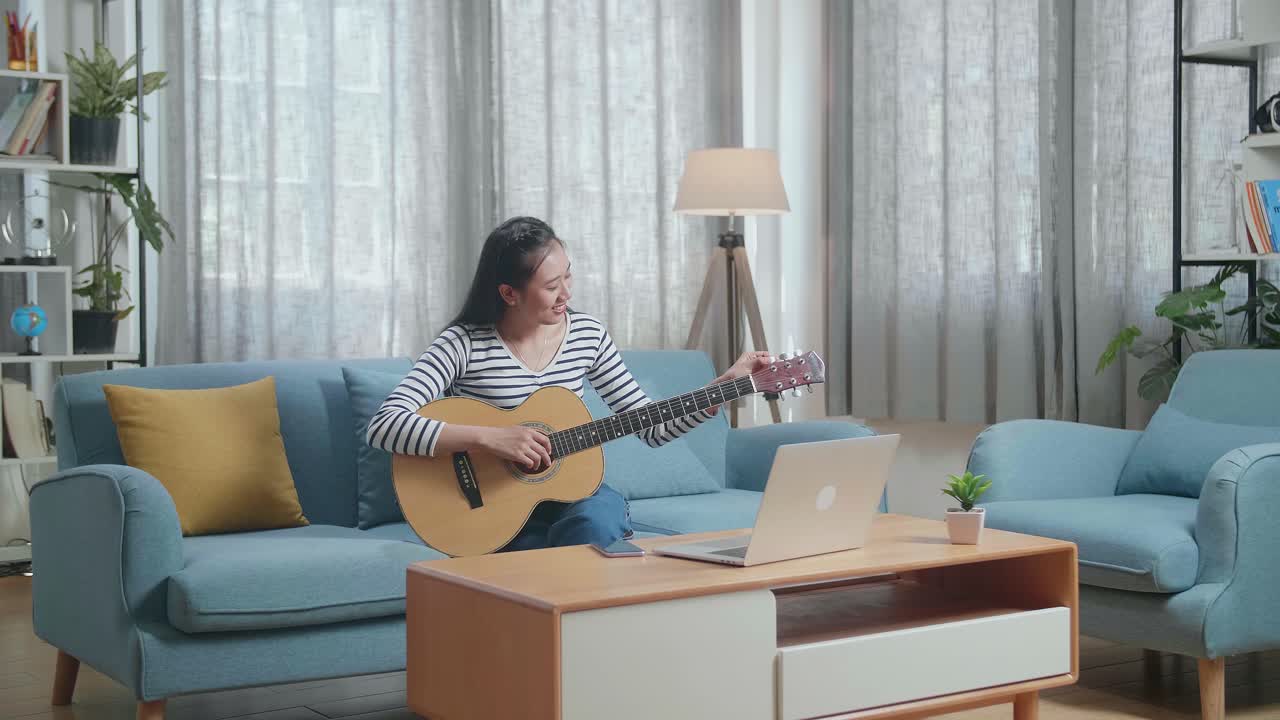 집에서 온라인으로 기타를 배우는 여성