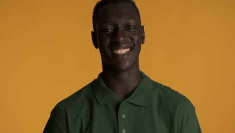 happy african american man on yellow background.