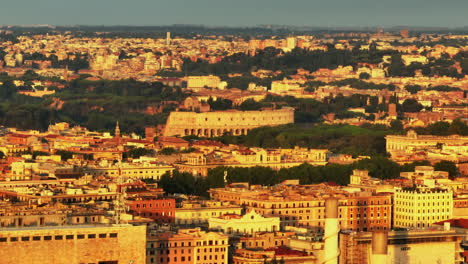 Buildings-in-city-illuminated-by-rising-sun.-Zoomed-slide-and-pan-footage-of-famous-Colosseum-amphitheatre--Rome,-Italy