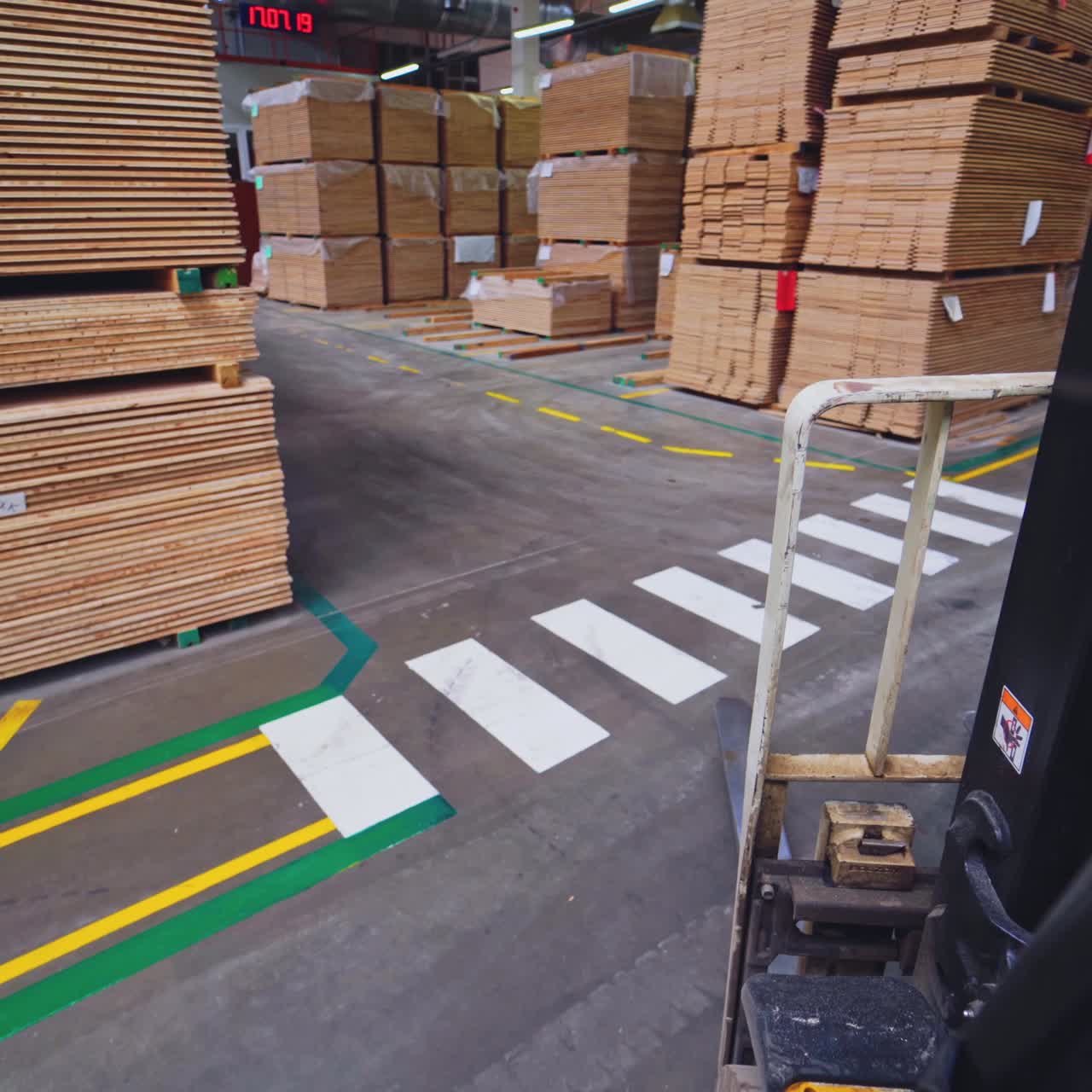 Production of wooden parquet. Piles of parquet boards inside the factory of furniture industry. View from forklift cart.