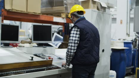 mature male worker setting printing machine