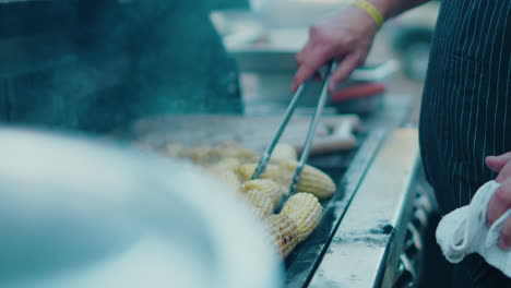 grilling corn on the cob, sausages and chicken at a food festival